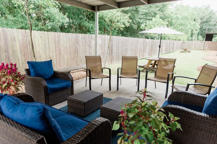 beautiful fenced in courtyard with covered patio and furniture - Victory Addiction Recovery Center - Lafayette addiction recovery center