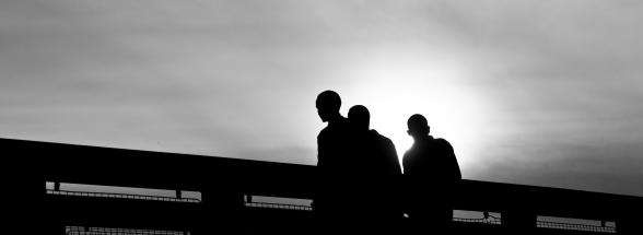 a black and white photo of three individuals standing together - victory addiction treatment center blog - standing together in recovery