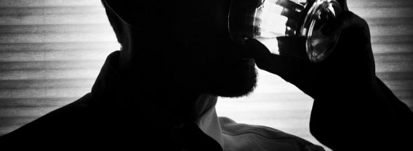 black and white photo of a man drinking alcohol - Victory offers alcoholics anonymous meetings and seminars