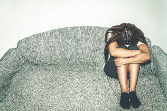 Addiction-and-Depression-Symptoms-and-Treatments - sad girl on couch head down