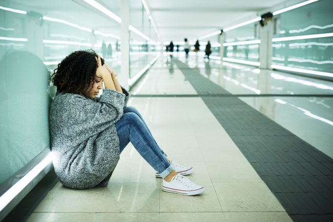 Signs-Your-Teen-Is-Using-Drugs-and-Alcohol - young upset girl sitting at airport or station