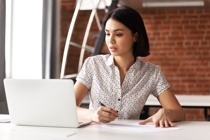 pretty Asian looking woman doing research on the computer - drug and alcohol