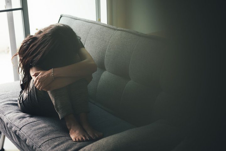 young woman in dark room with her head on her knees - Vicodin