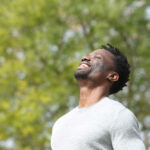 happy man outside looking up and smiling