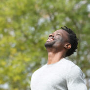 happy man outside looking up and smiling