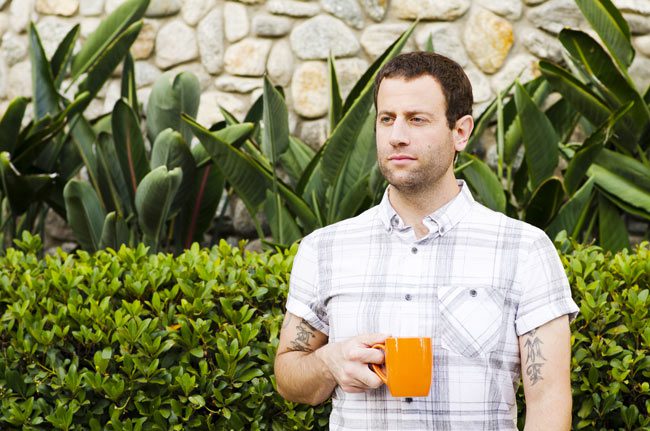 man outside drinking coffee