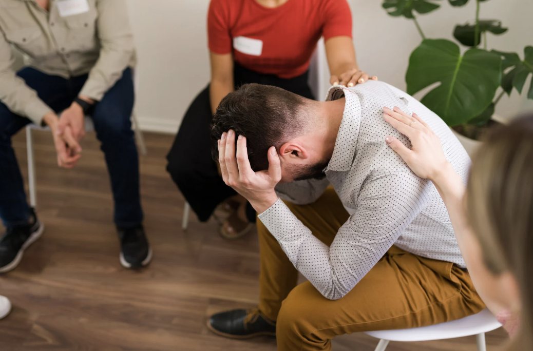 A man in a group therapy setting.